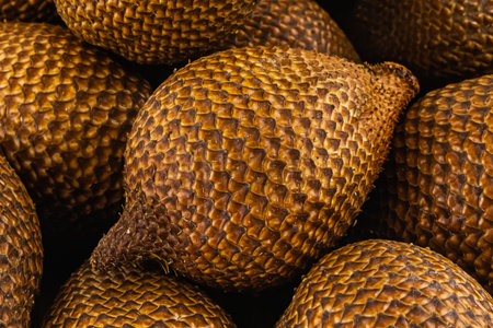 tropical herring fruit, snake fruit lies in a wooden bowl stands on a white backgroundの写真素材