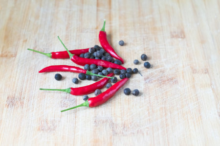 several bright hot red chili peppers on a wooden surface
