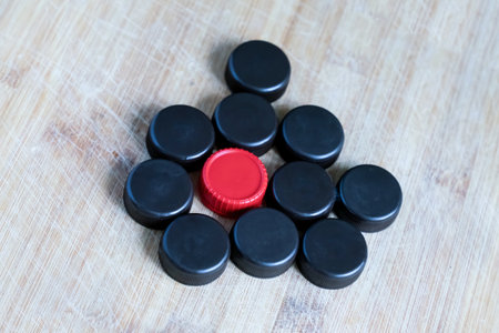 A bunch of colorful caps are piled on a wooden table.の写真素材