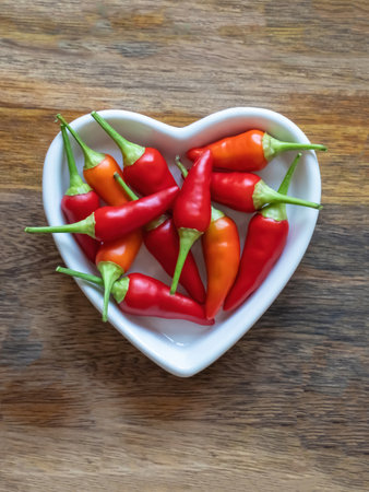 plate full of hot red peppers on wooden background with copy spaceの写真素材