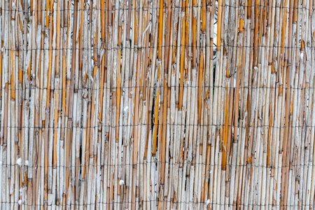 A fence made of sticks and wire. The fence is brown and whiteの写真素材