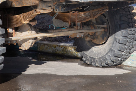 A truck with a large tire and a large suspension. The suspension is made of metal and is covered in...