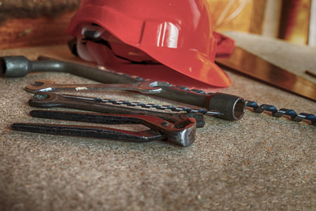 Red helmet and various tools lie on a neutral background