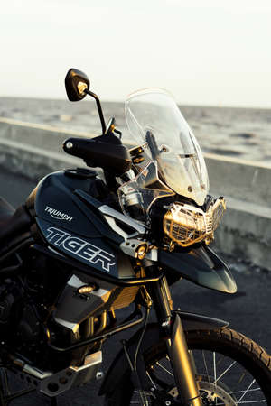 Samutprakran, Thailand - March 11, 2019 : triumph motorcycle new model 2018 triumph tiger xca on the road to beautiful sunset beach.のeditorial素材