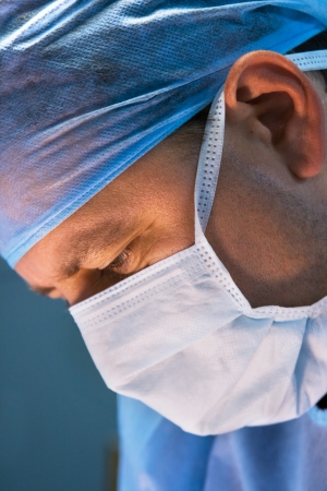 attentive look of working surgeon in operation roomの写真素材