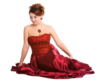 young attractive woman sitting in long red dress.の写真素材