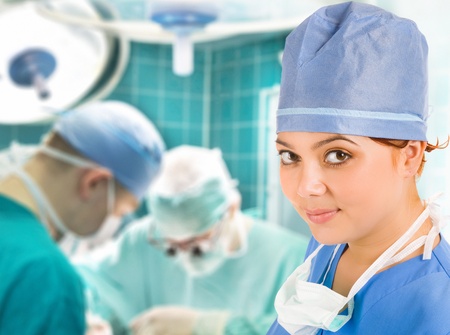 female doctor with surgical team and lamp on backgroundの写真素材