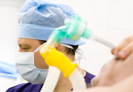 male anesthesiologist with patient working in operation roomの写真素材