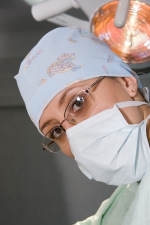 young surgeon woman with mask under lampの写真素材