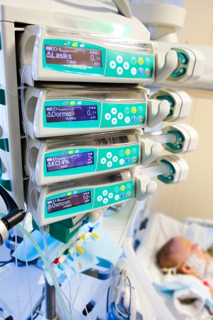 syringe pumps in pediatric intensive care unit with child on backgroundの写真素材