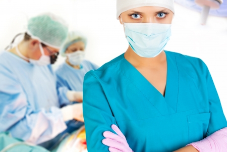 Female surgeon in operation room with working assistents on backgroundの写真素材