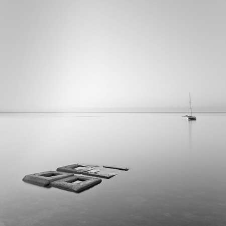 Black   White minimalist seascape with rocks   shipの写真素材