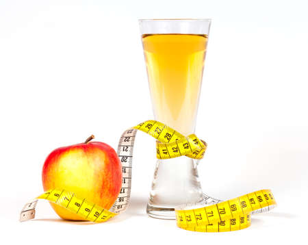 A yellow measuring tape wrapping red apple and juice - healthy eating conceptの写真素材