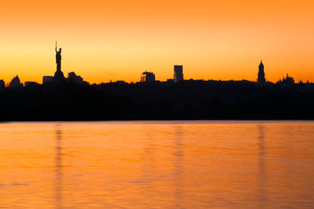 Kiev skyline and beautiful fiery sunset over river, Ukraineの写真素材