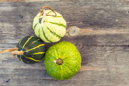 Autumn pumpkins with leaves on wooden board with shallow depth of fieldの写真素材