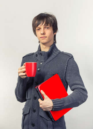 casual happy teenager with laptop and cupの写真素材