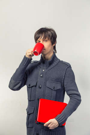 casual happy teenager with laptop and cupの写真素材