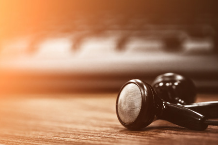 Stereo headphones placed on a desk computer.の写真素材