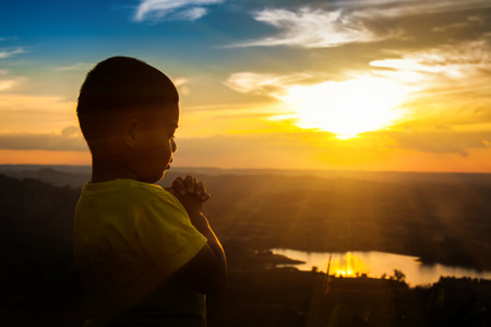 Boy praying on the Mount, thank God.の写真素材