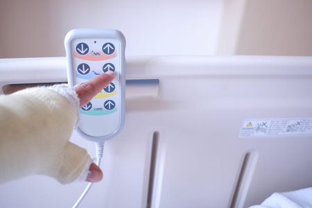 The patient is adjusting the bed by pressing the remote control.