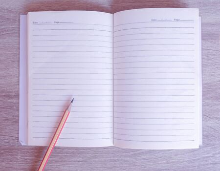 Pencil and wooden color on an empty book on the tableの写真素材