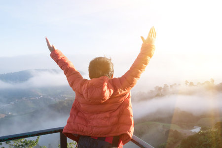 The boy raised his arms to pray to God on the mountain.