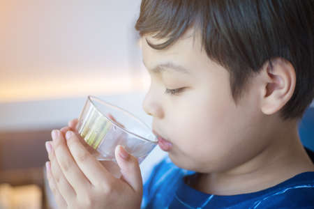 Boy drinking water in the morning. Drink water for health.の写真素材