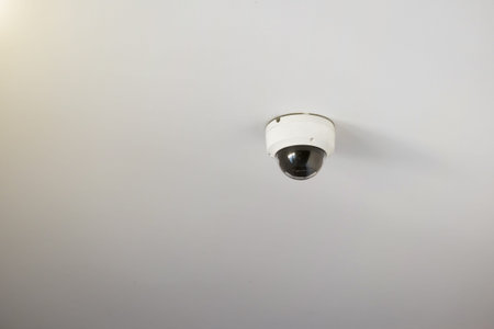 CCTV security camera mounted on a white ceiling.
