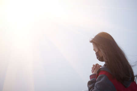 The girl prays to God and the cross.の写真素材