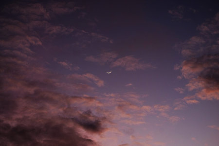 Moon and clouds in the sky at sunset. Beautiful natural background.