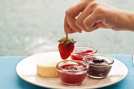 Heart shape cheesecake decorated with fresh strawberry on top and variety of topping sauceの写真素材