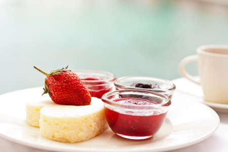 Heart shape cheesecake decorated with fresh strawberry on top and variety of topping sauceの写真素材