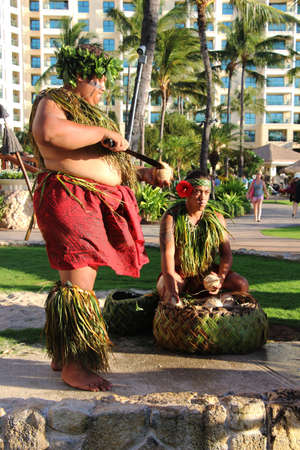 Hawaiian luau. A man in a traditional Hawaiian costume cutting a fresh picked coconut. Ko Olina, Oahu, Hawaii. The picture was taken in August 2015.のeditorial素材
