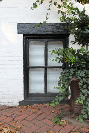 A ground level window of an old brick building. American colonial architectureの写真素材