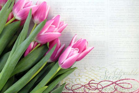 Pink tulips on vintage background: paper, newspaper. Spring flowers. A romantic floral background with copy spaceの写真素材
