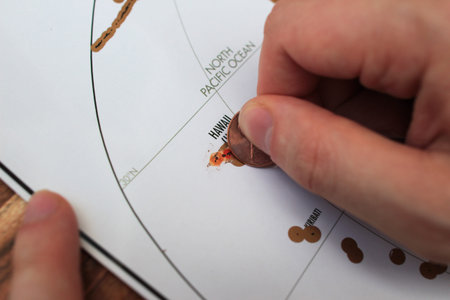 Man's hand scratching of visited places on a map. US travel. A travel destinations concept