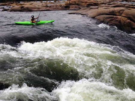 A man paddling his kayak through river rapidsのeditorial素材