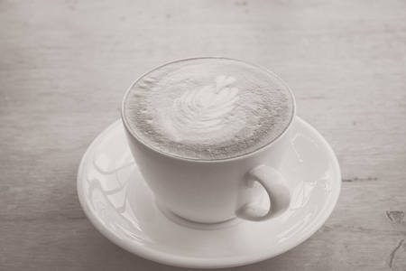 Latte art coffee on the wooden table. (vintage tone)の写真素材