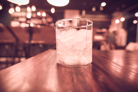 Ice in a glass on a wooden table. (vintage tone)の写真素材