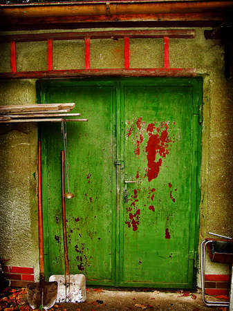 Old peeling door with garden toolsの写真素材