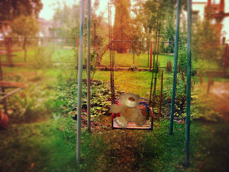 Garden swing with teddy bear and lomography vintage effectの写真素材