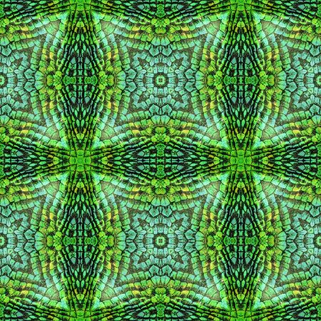 Abstract seamless reflective pattern of scales resembling snake skin. Green, turquoise and yellow background with star-shaped textureの写真素材