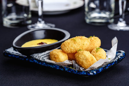 Fried mozzarella cheese sticks with cheese sauce and lime zest