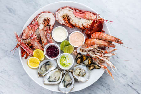 Fresh seafood platter with lobster, mussels and oysters on marble desk.の写真素材