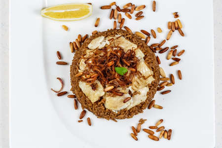 Traditional Middle Eastern fish and fried rice dish with fried pine nutsの写真素材
