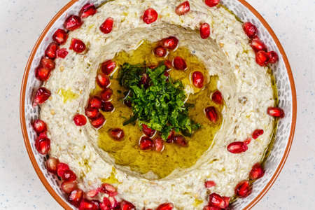 Arabic food Hummus with pomegranate in a traditional bowl.の写真素材