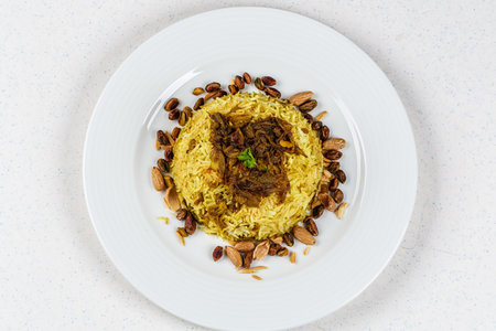 Traditional Middle Eastern fish and fried rice dish with fried pine nuts, chips and lemon.
