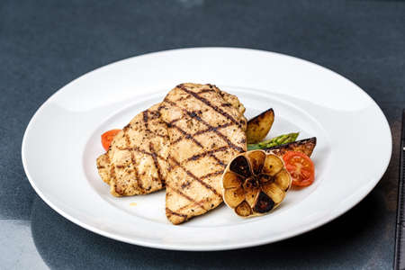 Grilled chicken fillet with french fries and asparagusの写真素材