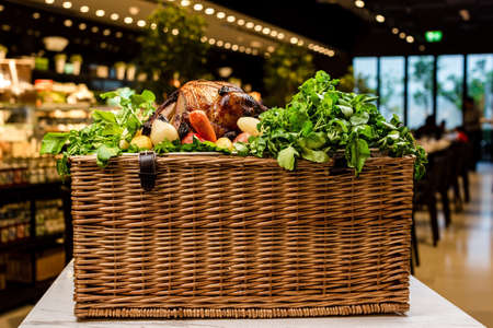 Garnished roasted turkey on platter on picnic basket served with herbsの写真素材