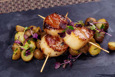 Grilled scallops with roasted young potatoesの写真素材